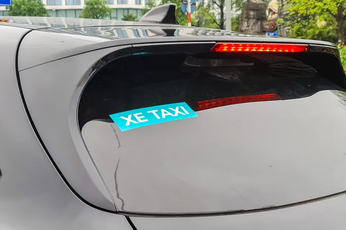  Dòng chữ "Xe taxi" được dán ở kính trước và sau. Đây cũng là chi tiết duy nhất giúp nhận biết đây là VinFast VF 8 thuộc GSM. Ngoài ra, biển xe màu vàng cũng là cách để nhận biết taxi điện với những chiếc VF 8 sử dụng cho gia đình. 