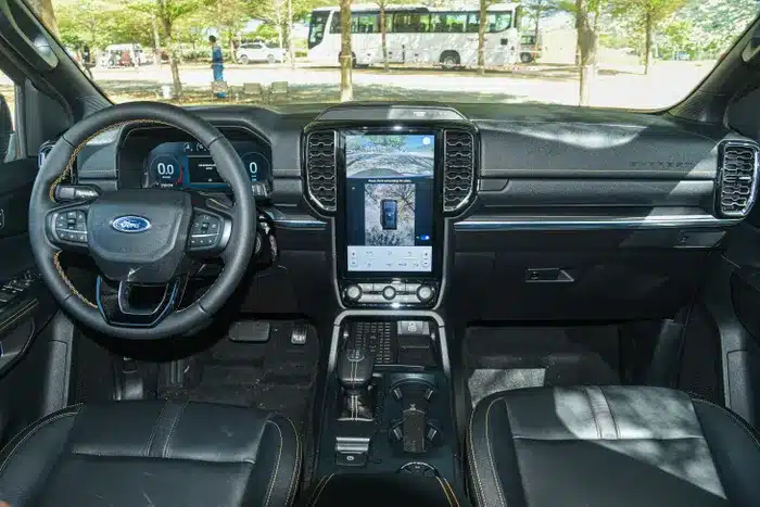  Bước vào bên trong, Everest Wildtrak có điểm nhấn là các đường chỉ khâu màu cam ở ghế ngồi, táp-lô, vô lăng... Vị trí trung tâm phía trước là màn hình giải trí 12 inch SYNC 4, hỗ trợ kết nối Apple CarPlay/Android Auto không dây. 